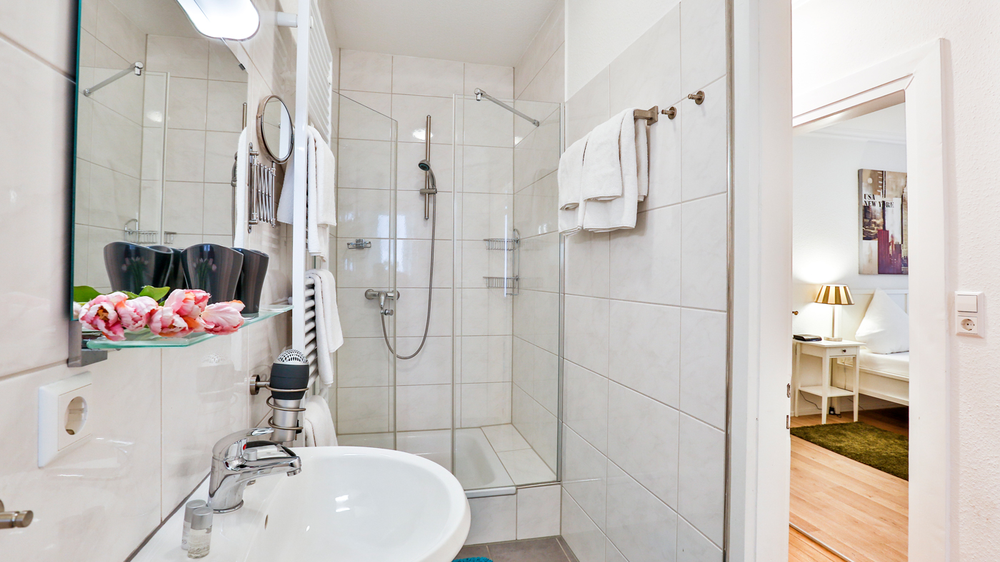 Badezimmer mit weißen Fliesen im Hotel Laterne in Baden-Baden.